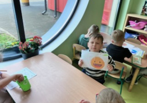 Chłopiec prezentuje efekt pracy w grupie